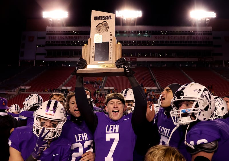 Lehi ’s Jace John hoists up the team’s trophy