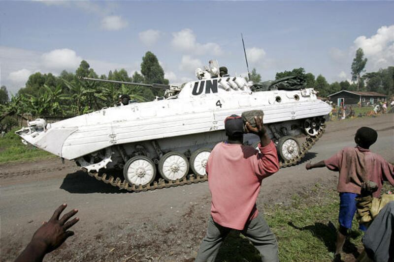 People stone United Nations peacekeepers in an APC tank as they pass through the village of Kibati some 7 1/2 miles north of Goma in eastern Congo Tuesday. Thousands of refugees are fleeing fighting between government forces and rebels of renegade Gen. La