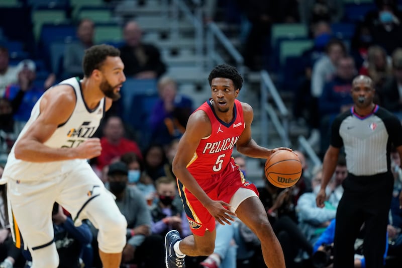 New Orleans Pelicans forward Herbert Jones, wearing red, moves the ball down court against Utah Jazz center Rudy Gobert