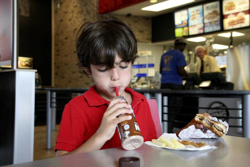 Sebastiasn Antorcha eats one of the hamburger healthy meals at a south Miami Burger King Tuesday, July 12, 2011.