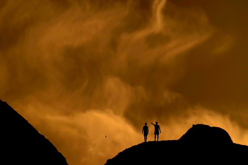 People watch the sunset from a peak at Papago Park, Feb. 19, 2021, in Phoenix. This week is forecast to be the hottest week of the summer.