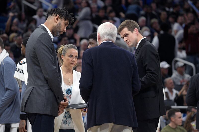 San Antonio assistant Will Hardy, right, joins other assistants during a huddle on the sidelines with head coach Gregg Popovich.