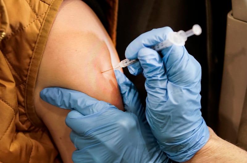Jaynie Murdock receives her booster shot at a drive-thru vaccination in Farmington.