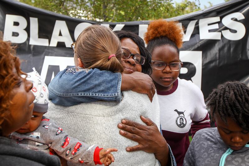 FILE - Supporters hug members of Patrick Harmon's family at the rally demanding justice for the August death of Patrick Harmon at the Public Safety Building in Salt Lake City Saturday, Sept. 30, 2017. The children of Patrick Harmon, a black man fatally sh