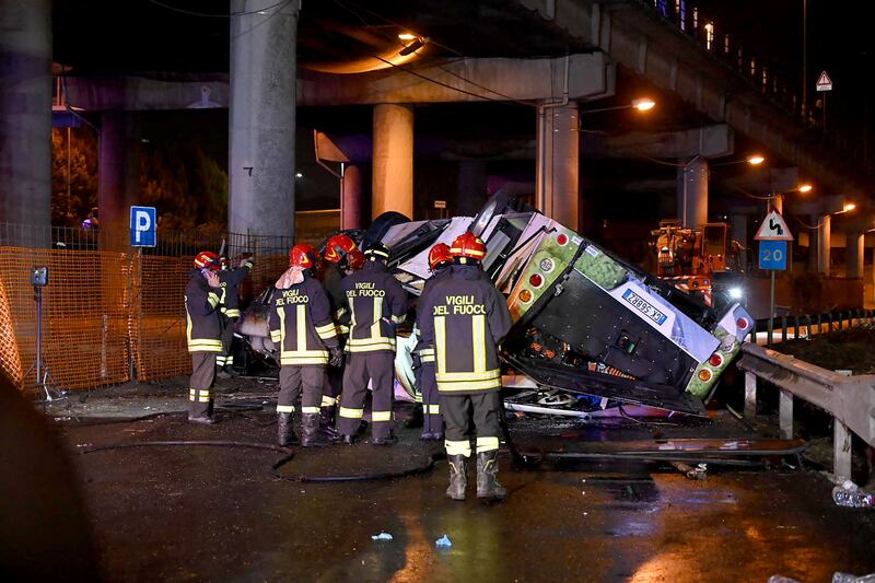 Firefighters work on the site of a bus accident on in Mestre, near Venice.