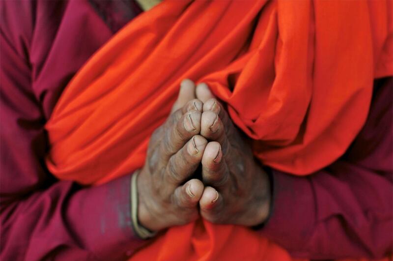 A Buddhist monk from Cambodia offers prayers outside the Sera Monastery west of Bangalore, India.
