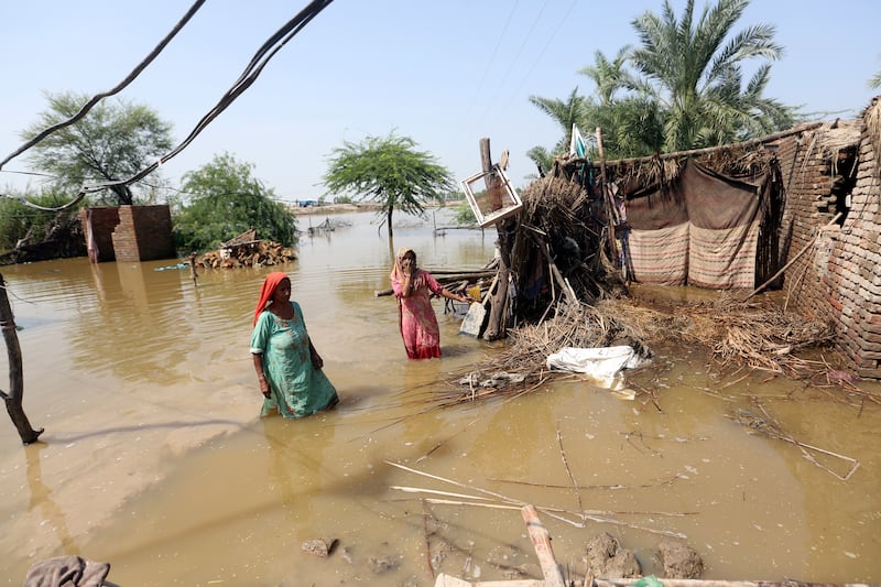 Women wade through a flooded area after heavy rains in the Shikarpur district of Sindh province, Pakistan.