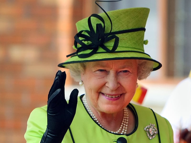 Britain’s Queen Elizabeth II waves to guests, patients and staff at the Mildmay HIV Centre in Kampala, on the first day of her state visit to Uganda.