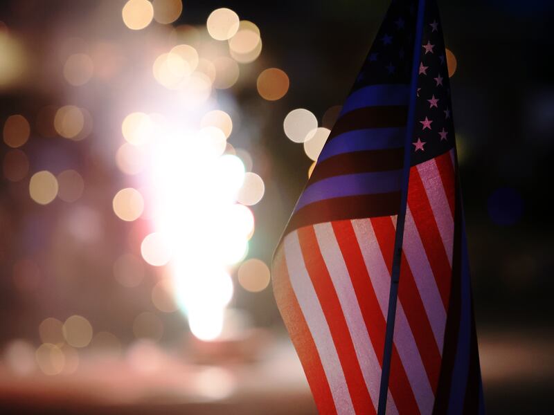 A small American flag is illuminated by fireworks on July 4, 2022.