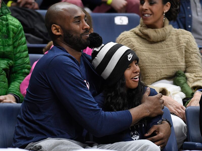 In this March 2, 2019, file photo Kobe Bryant and his daughter Gianna watch the first half of an NCAA college basketball game between Connecticut and Houston in Storrs, Conn.
