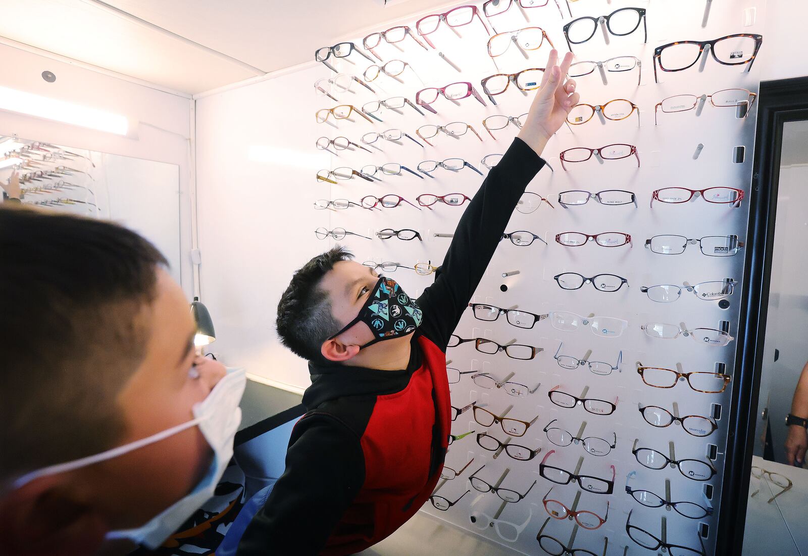 Santi Morales, 9, picks out eyeglass frames as EyeCare4Kids and its mobile clinic visit North Salt Lake.