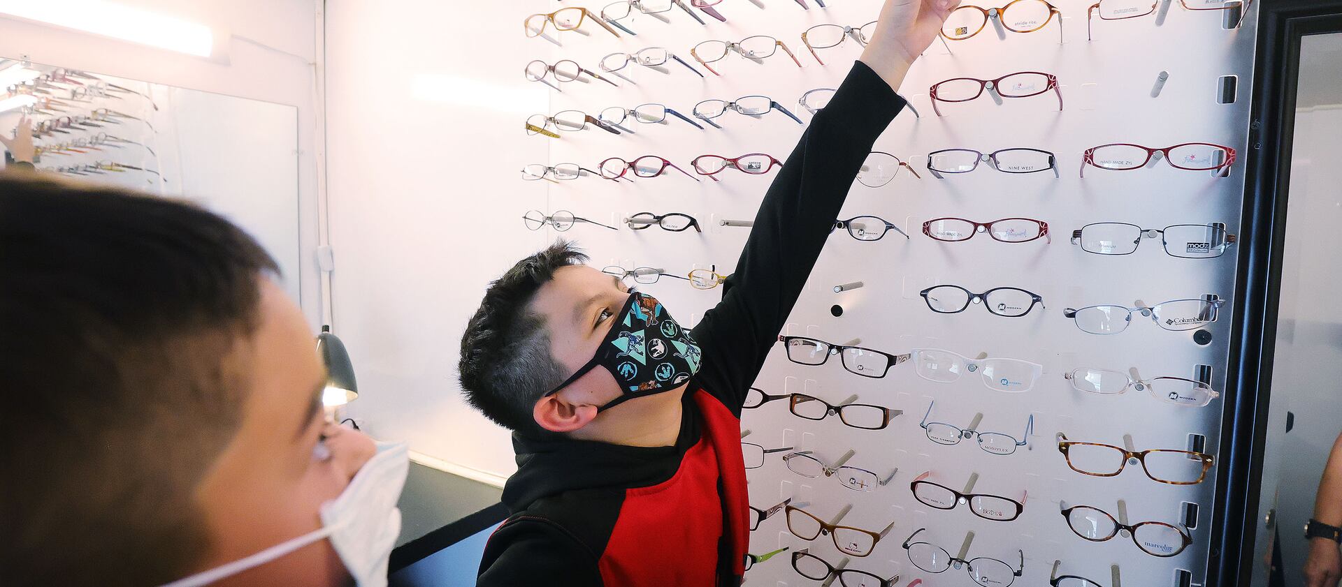 Santi Morales, 9, picks out eyeglass frames as EyeCare4Kids and its mobile clinic visit North Salt Lake.