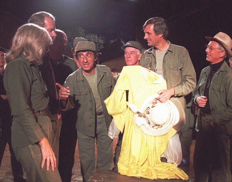 Members of the "M_A_S\*H" cast gather around to bury Klinger's yellow dress in a foot-locker time capsule during taping of the show's final episode in January 1983. The 2 1/2-hour finale was the highest-rated television show in Nielsen Media Research unti