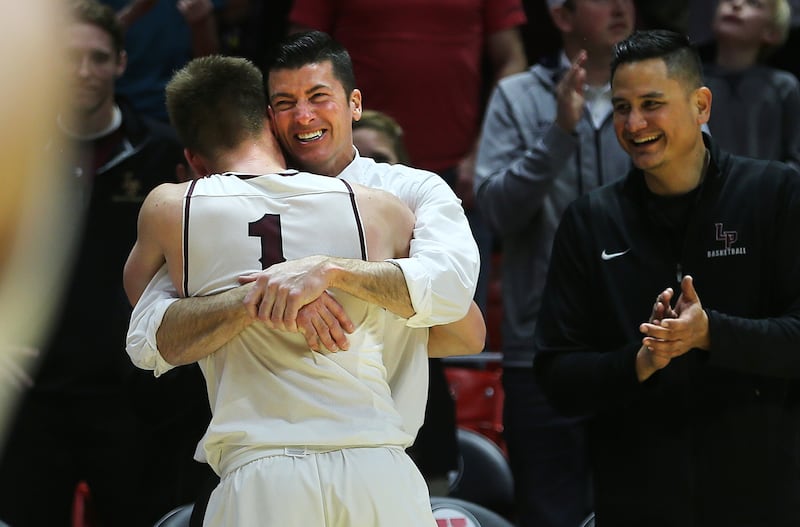 Lone Peak Head Coach David Evans hugs Max Brenchley as he comes out of the game as the Knights defeat Pleasant Grove in the 6A basketball championship in the Jon M. Huntsman Center at the University of Utah on Saturday, March 3, 2018.