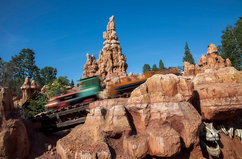 A train zips through Big Thunder Mountain and past the historic Rainbow Ridge Mining Town. Big Thunder Mountain Railroad, a popular roller coaster attraction, is located in Frontierland at Disneyland Park in Anaheim, Calif. For editorial news use only.