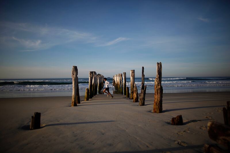 A woman runs along St Clair Beach in Dunedin, New Zealand.