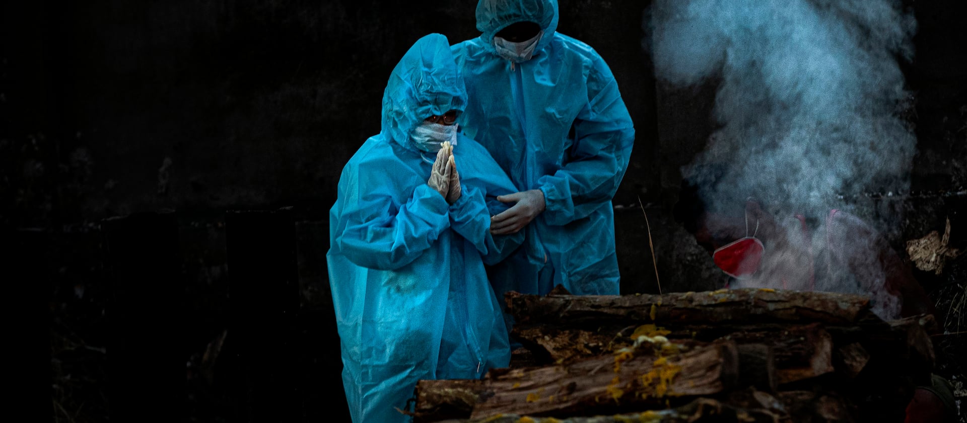 A 9-year-old boy, left, wearing personal protective equipment performs rituals during the cremation of his father who died of COVID-19 in Gauhati, India, Monday, Sept. 28, 2020.