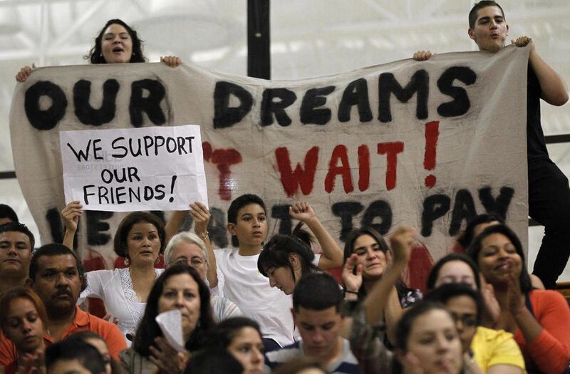 FILE - In this Sept. 26, 2011 photo, college student Jasmine Oliver, of Warwick, R.I., top left, and Javier Gonzalez, of Pawtucket, R.I., top right, display a banner and shout their support for allowing illegal immigrants to pay in-state tuition rates whi