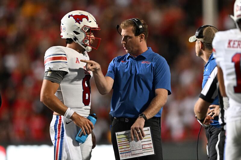 SMU head coach Rhett Laslee, second from left, talks with quarterback Tanner Mordecal, left, during a timeout in the first half of an NCAA college football game against Maryland, Saturday, Sept. 17, 2022, in College Park, Md.