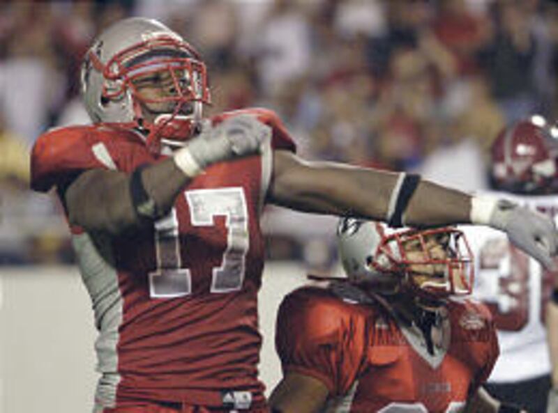 New Mexico's Billy Strother, left, and Daniel Ramirez celebrate after recovering a New Mexico State fumble on a punt play.