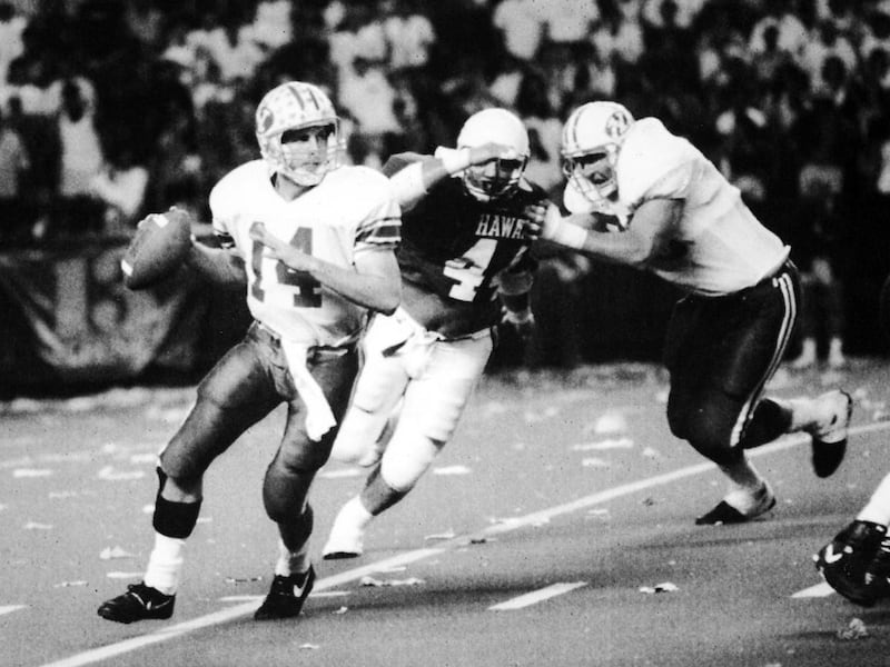 Ty Detmer searches for a receiver as Hawaii's David Tanuvasa closes in. Hawaii defeated BYU 59-28 in their final regular season game.