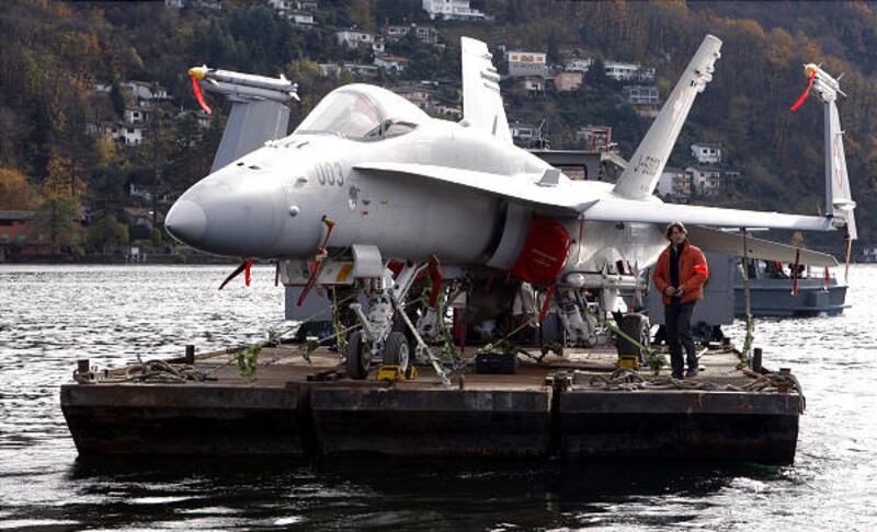 An FA-18 fighter is transported across Lake Lugano in Switzerland from the port of Agno Tuesday. The jet will be displayed during the Swiss Army Days exhibition next week in Lugano.