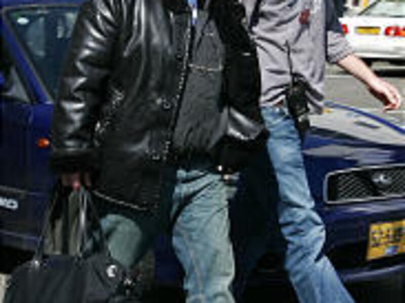 Suspected Israeli mob boss Zeev Rosenstein is escorted to a flight bound for Miami Monday.