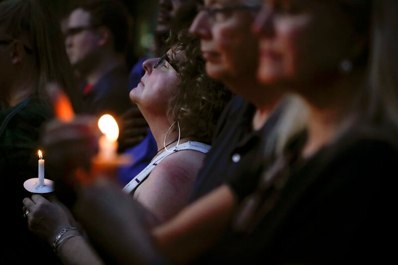 Mourners pause for a prayer as they gather for a vigil at the scene of a mass shooting, Sunday, Aug. 4, 2019, in Dayton, Ohio. Multiple people in Ohio were killed in the second mass shooting in the U.S. in less than 24 hours. (AP Photo/John Minchillo)