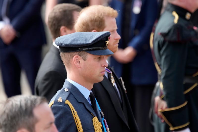 Prince William and Prince Harry walk behind the coffin of Queen Elizabeth II being pulled past Buckingham Palace.