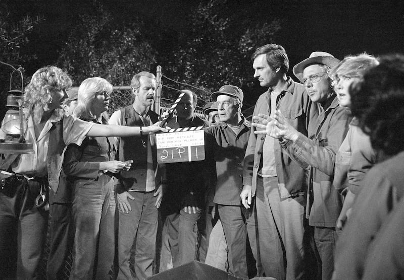 A crew member holds up a clacker as some of the actors it to begin filming the final shot of the hit television series, "M_A_S_H," in Los Angeles on Jan. 14 1983. From left are Loretta Swit (Maj. Margret "Hot Lips" Houlihan): Mike Farrell (B.J. Hunnicut);