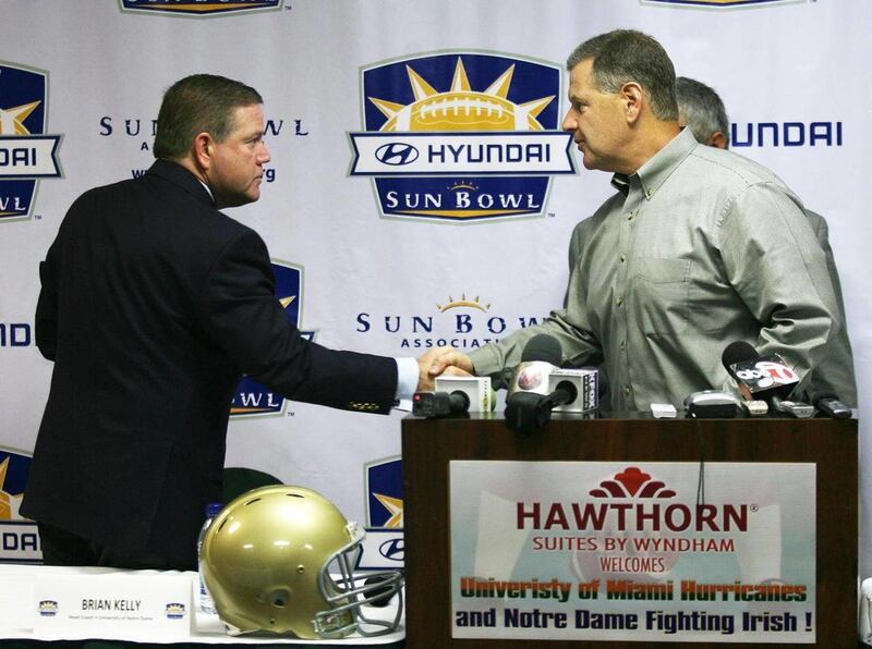 Notre Dame coach Brian Kelly, left, and Miami coach Jeff Stoutland exchanged a handshake at the conclusion of a press conference Tuesday Dec. 28, 2010 in El Paso, Texas. They are preparing their teams for Friday's Hyundai Sun Bowl.