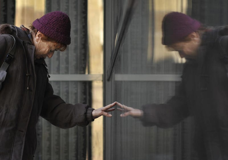 Holocaust survivor Eva Szirtes pays respect to relatives at a memorial wall bearing the engraved names of tens of thousands of victims of the Nazi Holocaust at the Holocaust Memorial Center, during Holocaust remembrance day in Budapest, Hungary, Friday, J