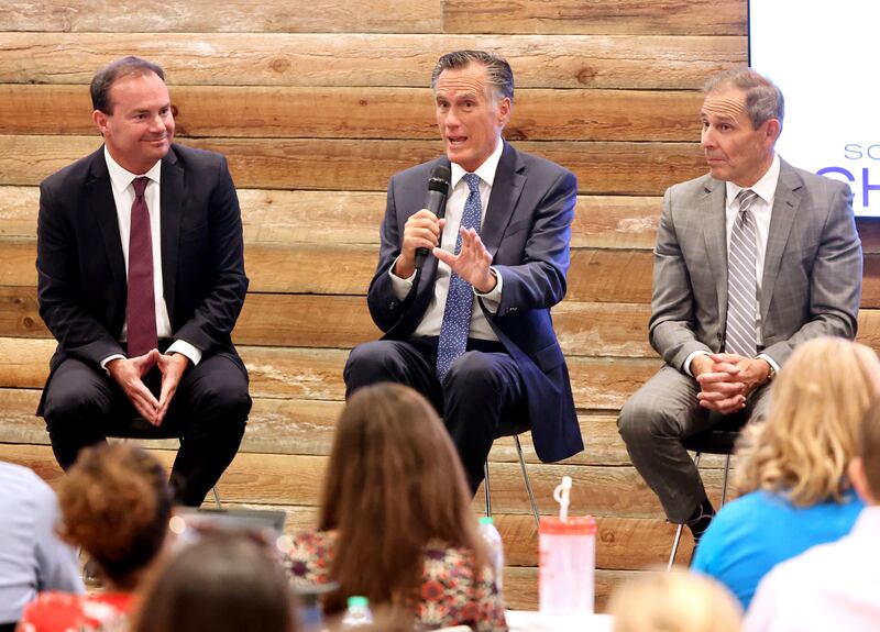 Sen. Mike Lee, R-Utah, listens as Sen. Mitt Romney, R-Utah, addresses the South Valley Chamber of Commerce.