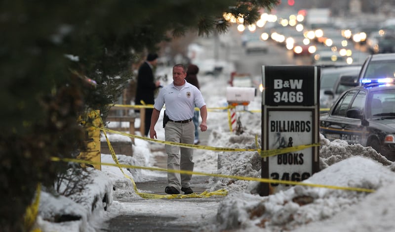 An investigator walks through the crime scene tape where a 64-year-old woman was found stabbed to death inside the business B & W Billiards and Books on 3466 S. 700 East Tuesday, Nov. 30, 2010, in South Salt Lake City, Utah. (Tom Smart, Deseret News)