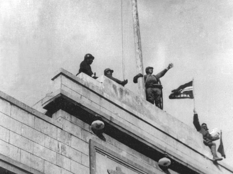 In this Dec. 1937 file photo Japanese soldiers cheer as they hoist their flag from the roof of the central government building after they seized Nanking in the Second Sino Japanese War. Japan acknowledged its wartime military caused tremendous damage to C