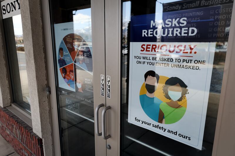 “Masks required” signage is pictured on the front doors of Pixels Foto & Frame in Sandy on Monday, April 5, 2021.