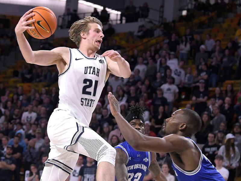 Utah State forward Norbert Thelissen (21) drives to the basket as New Orleans forward Simeon Kirkland defends.