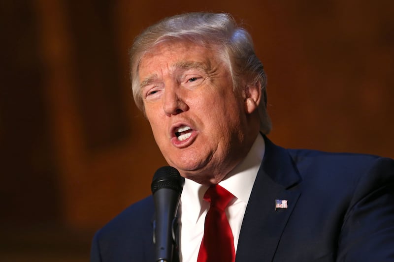 Former President Donald Trump speaks into a microphone at a press conference