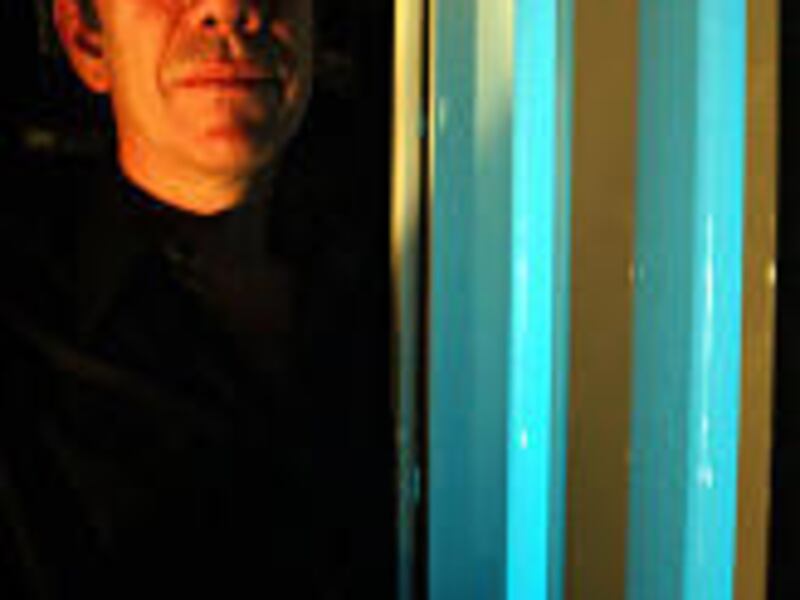 Charles Bolta, president of American Environmental Products Inc., shows how two Glow-Lux bulbs shine after the power goes off.