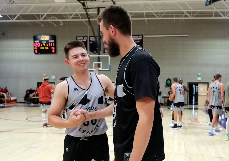 Rylan Jones, left, and Zac Seljaas shake hands during a Powder League basketball game at American Preparatory Academy.