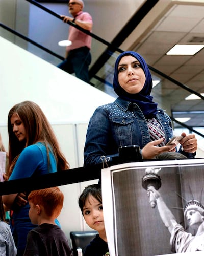 Rasha Hredeen and one of her sons, Omar, wait for the arrival of their Syrian cousins, flying from Jordan as refugees, at the Salt Lake City International Airport.