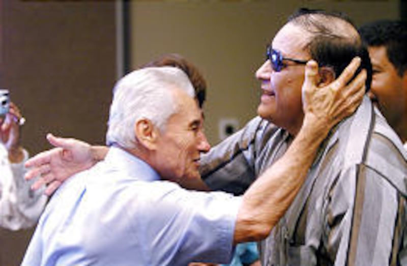 Yiye Avila, considered the Billy Graham of Latin America, greets Salt Lake's Gustuva Mena Sr. on Monday.