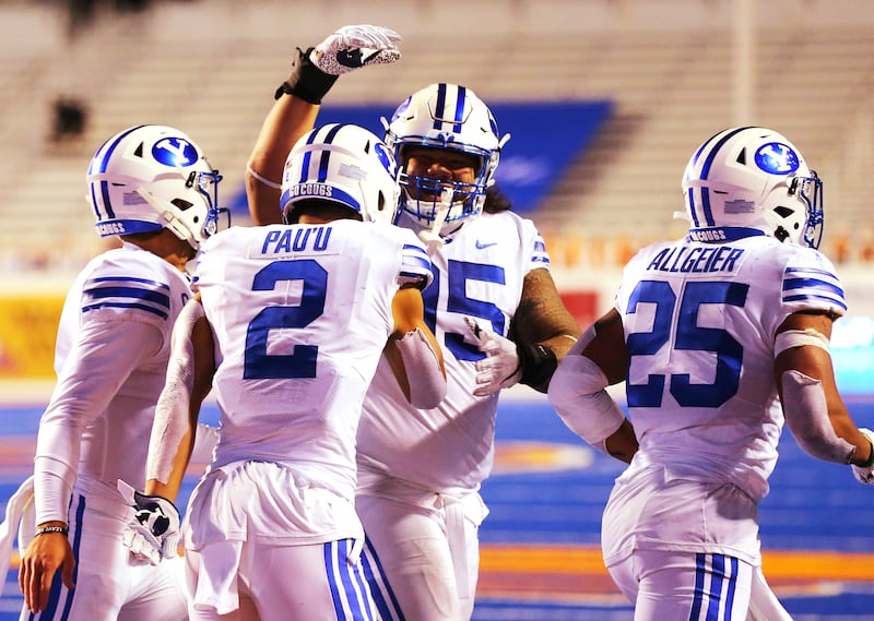 Brigham Young Cougars wide receiver Neil Pau’u (2) celebrates a touchdown with teammates.