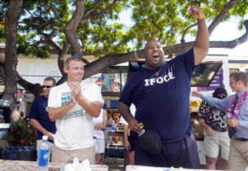 Eric "Badlands" Booker, right, celebrates his win at the Maui Onion Eating Contest during the annual Maui Onion Festival in August 2004. At left is fellow competitor Eric Siegmund.