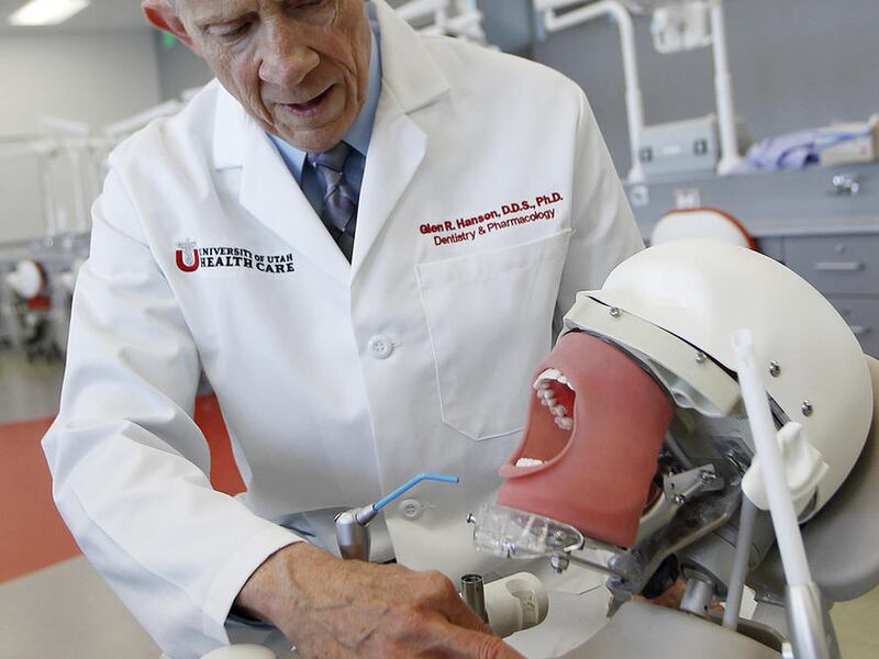 FILE — Glen Hanson demonstrates a patient simulation machine at the University of Utah School of Dentistry in Salt Lake City, Monday, June 29, 2015. The University of Utah School of Dentistry has agreed to help foot the bill for a specific population of p