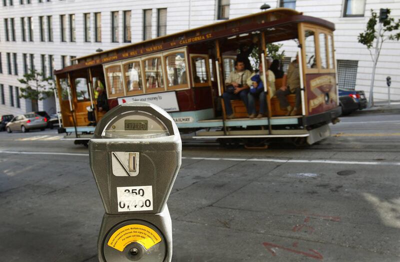 In this Oct. 27, 2009 file photo, a cable car passes a parking meter near San Francisco's financial district. San Francisco City Attorney Dennis Herrera on Monday, June 23, 2014 issued a cease-and-desist demand to a mobile app called Monkey Parking, which