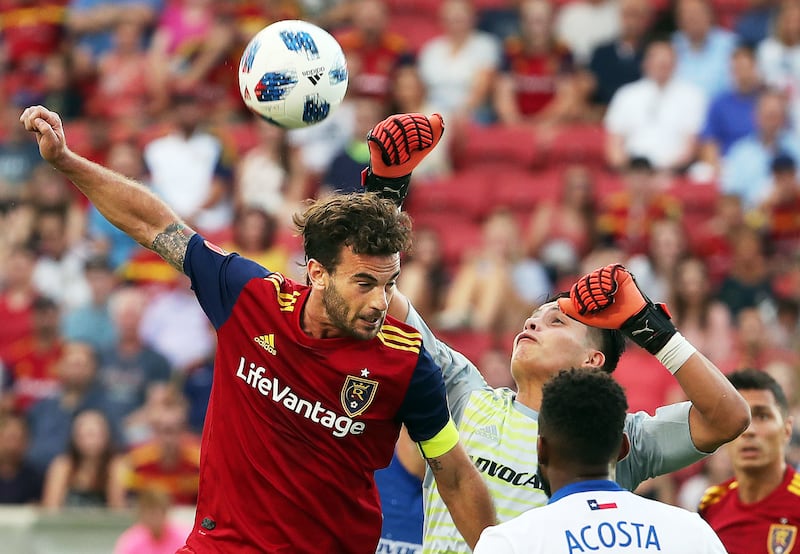 Real Salt Lake midfielder Kyle Beckerman (5) tries for a header against FC Dallas goalkeeper Jesse Gonzalez (1) during MLS soccer in Sandy on Saturday, July 7, 2018.