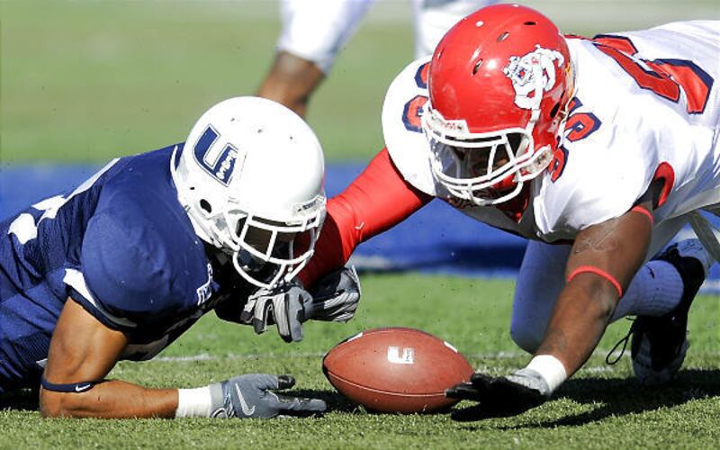 Utah State's Otis Nelson and Fresno State's Nico Herron both dive for a fumbled ball on Saturday afternoon in Romney Stadium.