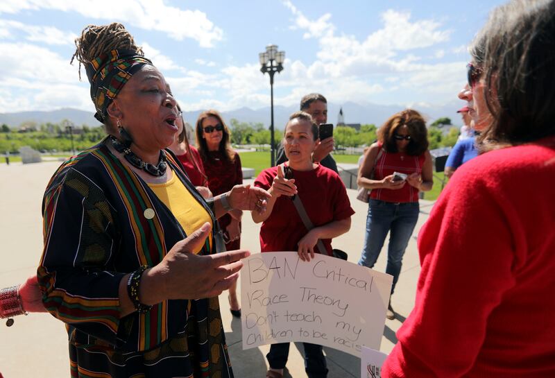 Betty Sawyer, left, a supporter of critical race theory, exchanges views with a group opposed to the theory, after a protest in Salt Lake City.