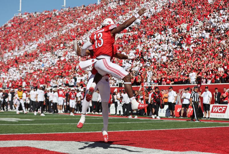 Utah Utes quarterback Nate Johnson (13) celebrates a touchdown with Utah Utes receiver Landen King (82) in Salt Lake City.